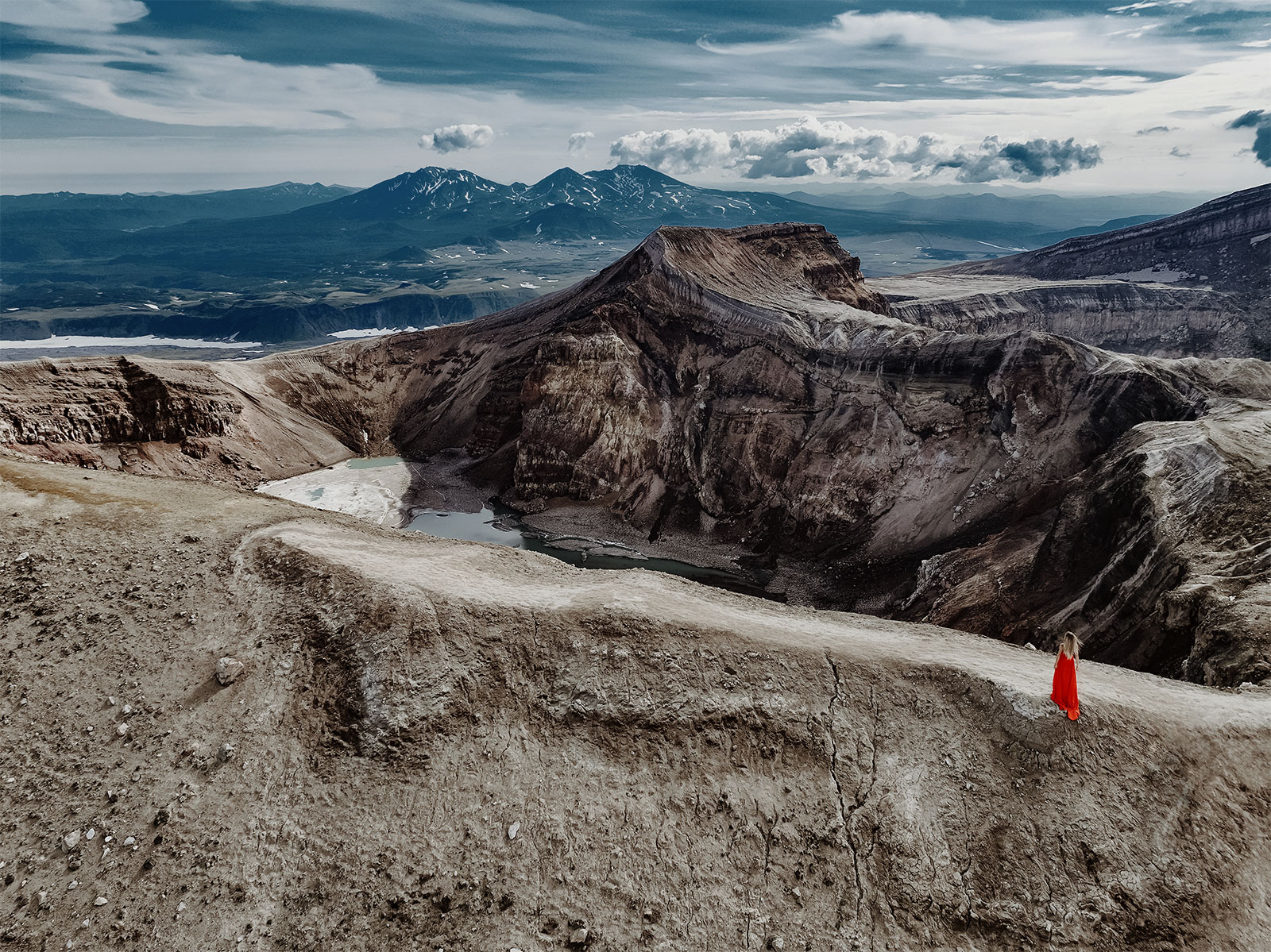 Девушка в красном платье у кратера вулкана